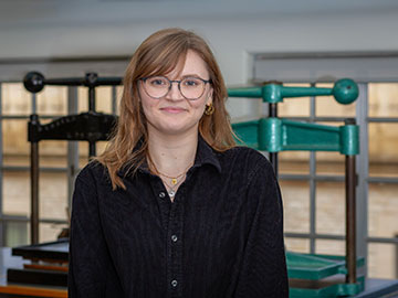 A woman with long hair and glasses wearing a black shirt