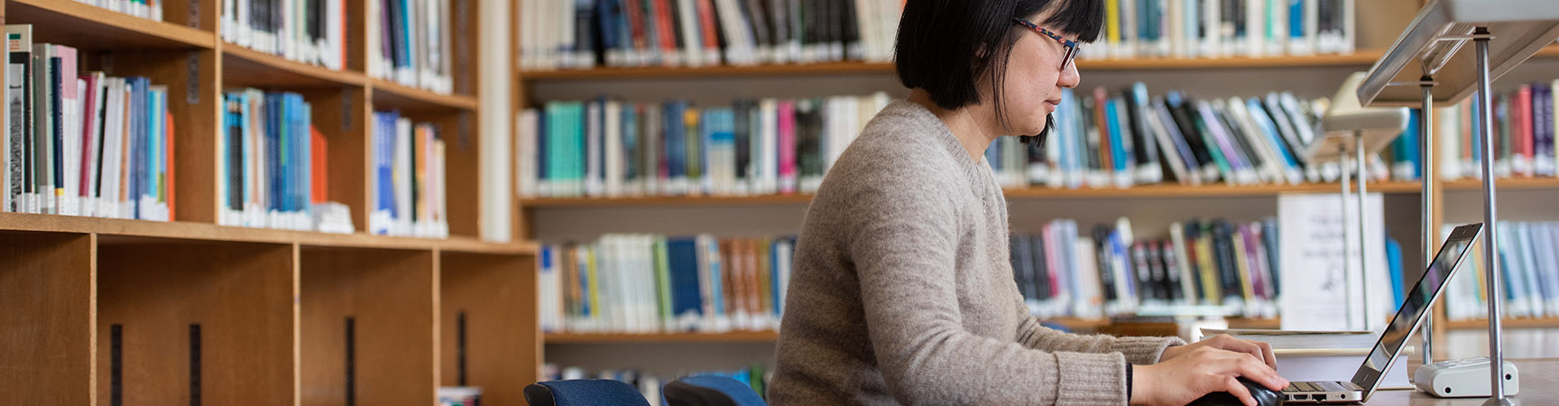 A woman works at her laptop at a desk