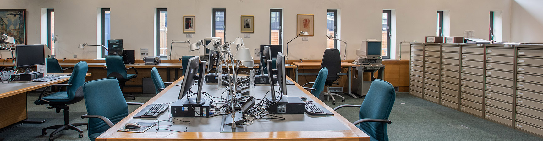 A long wide desk with desktop computers on either side