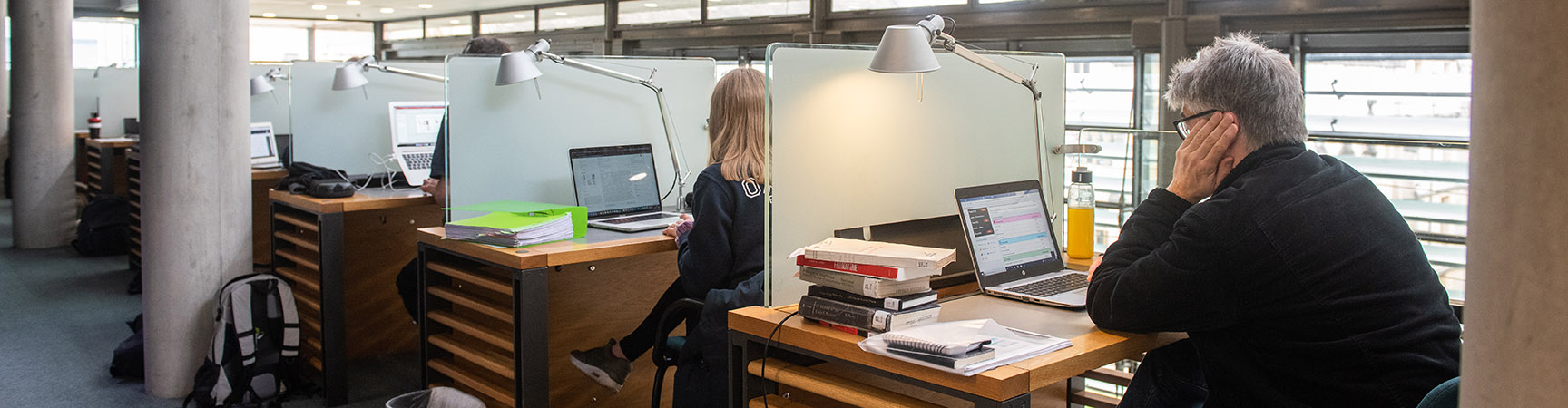 A row of individual desks with a student sitting at each one